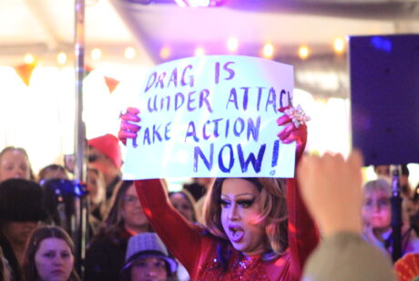 Drag queen Coco Freeo holding a sign up protesting the laws in the Idaho legislature | Connor Anderson | KUOI 89.3